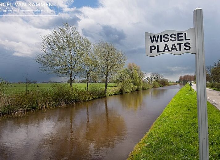 Uitzicht vanaf de brug op de rustige omgeving van Huisje in Driezum, een vakantiehuis in het Friese platteland.