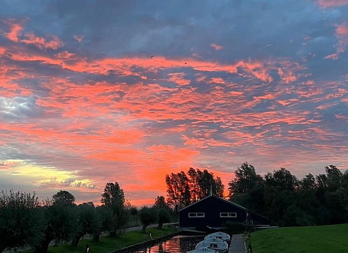 Houten eettafel in Vakantiehuisje in Westhem met panoramisch uitzicht op het Friese platteland, Friesland.
