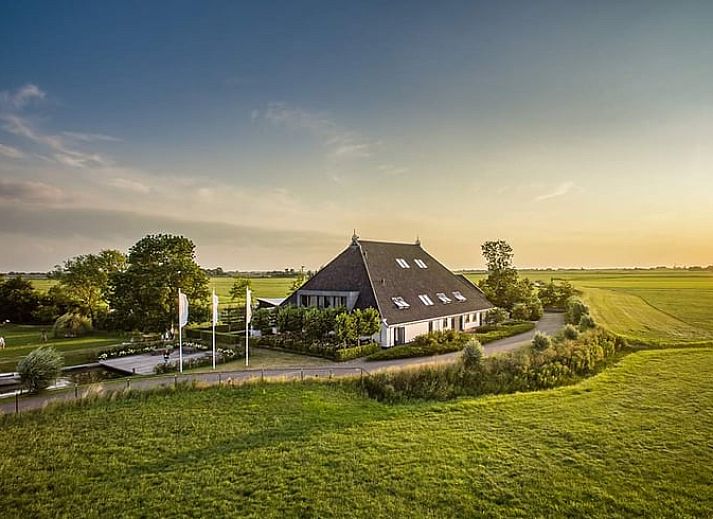 Houten eettafel in Vakantiehuisje in Westhem met panoramisch uitzicht op het Friese platteland, Friesland.