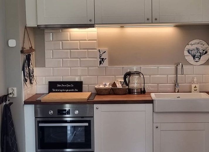 Cozy terrace at Holiday home in Bantega, Friesland, overlooking the countryside at sunset.