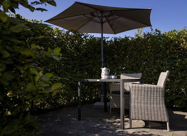 Woonkamer van Huisje in Greonterp met koeienmuurschildering en comfortabele zithoek, Friesland.