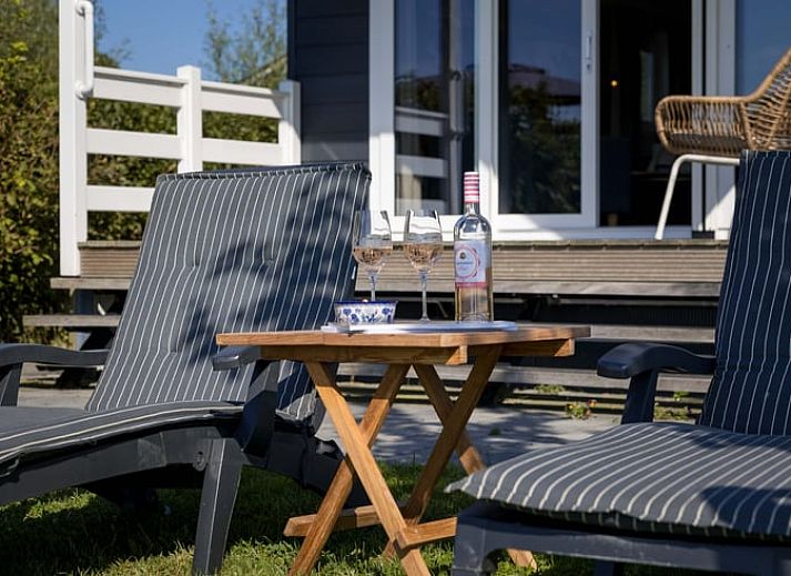 Woonkamer van Huisje in Greonterp met koeienmuurschildering en comfortabele zithoek, Friesland.