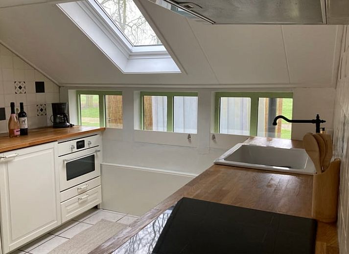 Gezellige zithoek in vakantiehuis Huisje in Loenga, Friesland, met houten vloer.