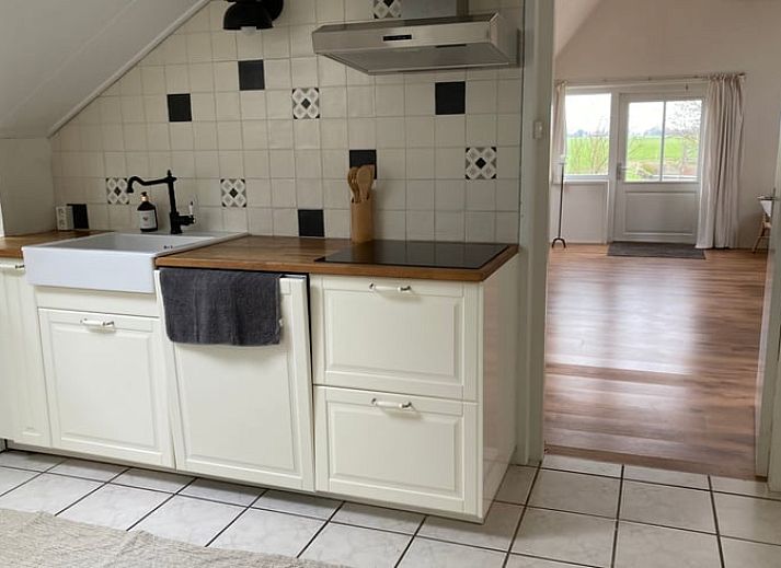 Gezellige zithoek in vakantiehuis Huisje in Loenga, Friesland, met houten vloer.