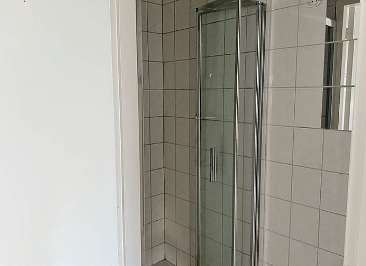 Ruime woonkamer met veel lichtinval in Huisje in Loenga, ideaal voor ontspanning.