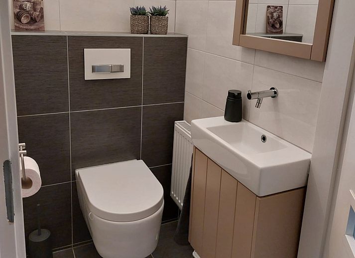 Cozy living room of vacation home FR440 in Friesland with comfortable sofa and natural light.