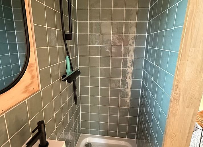 Winterse charme van Huisje in Surhuisterveen met besneeuwd terras in Friesland.