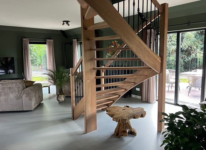 Ferienhaus in Spanga mit Blick auf die ueppige friesische Landschaft und traditionelle Architektur.