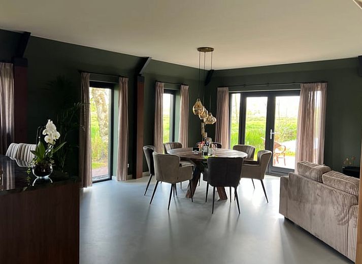 Ferienhaus in Spanga mit Blick auf die ueppige friesische Landschaft und traditionelle Architektur.