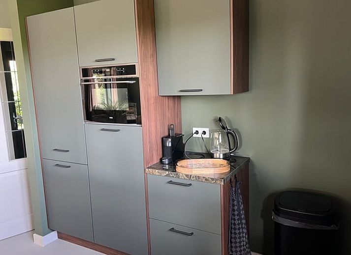 Moderne Kueche im Ferienhaus in Spanga, Friesland, mit Insel und stilvollem Dekor.