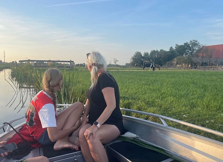 Dining area in vacation home Cottage in Goenga with wooden table and country style in Friesland.