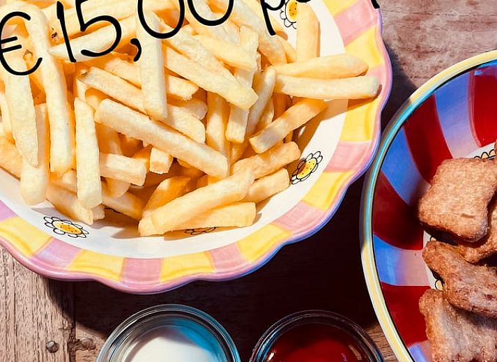 Dining area in vacation home Cottage in Goenga with wooden table and country style in Friesland.