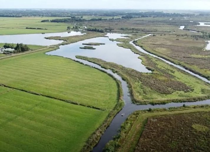 Gezellige binnenruimte van Vakantiehuisje in Feanwalden met houtkachel en eettafel.
