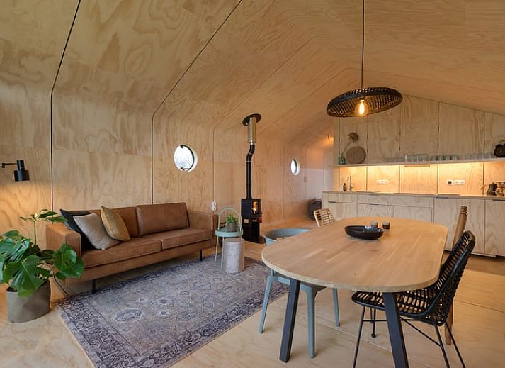 Ferienhaus in Broek in der friesischen Landschaft, modernes Holzhaus mit grosser Glasfassade und Aussicht auf die gruene Umgebung.