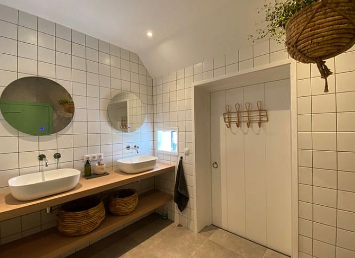 Binnenruimte van Vakantiehuis in De Hoeve, Friesland, gezellig ingericht met rieten stoelen.