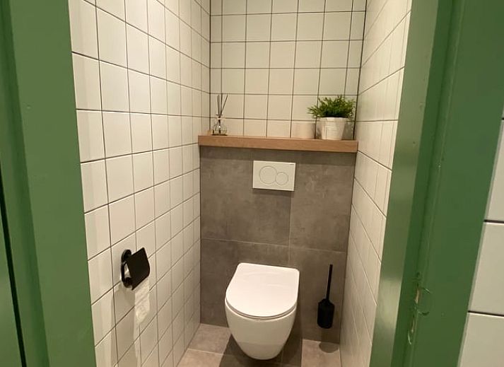 Uitzicht vanuit Vakantiehuis in De Hoeve over het Friese platteland, met moderne stoelen op het terras.