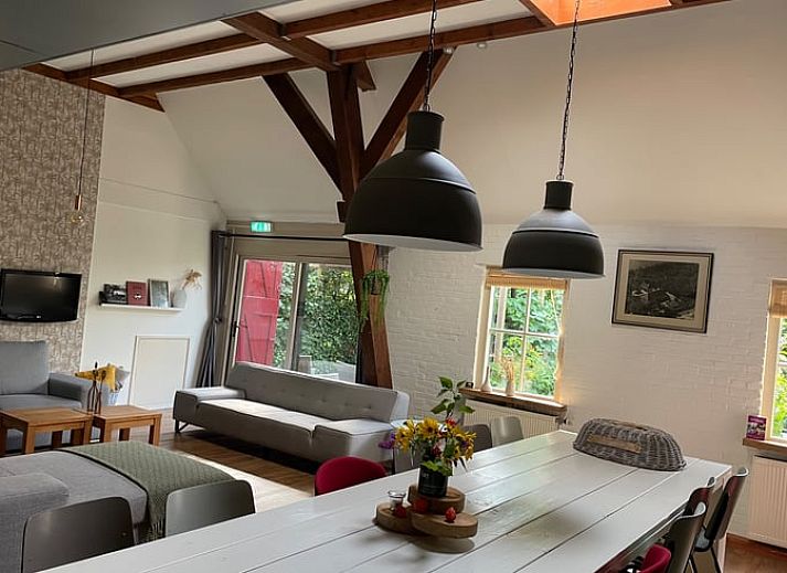 Ferienhaus in Hegebeintum in der friesischen Landschaft, attraktiver Aussenbereich mit Reetdach und bluehendem Garten.