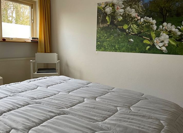 Gemuetliches Wohnzimmer im Ferienhaus in Hegebeintum, Friesland, mit bequemen Sofas und Holzboden.