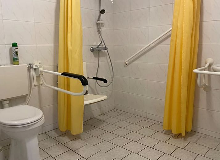 Gemuetliches Wohnzimmer im Ferienhaus in Hegebeintum, Friesland, mit bequemen Sofas und Holzboden.