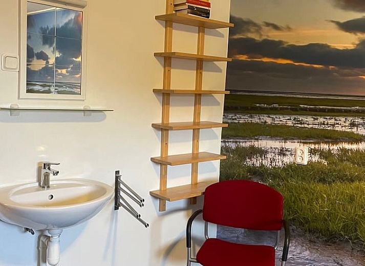 Gemuetliches Wohnzimmer im Ferienhaus in Hegebeintum, Friesland, mit bequemen Sofas und Holzboden.