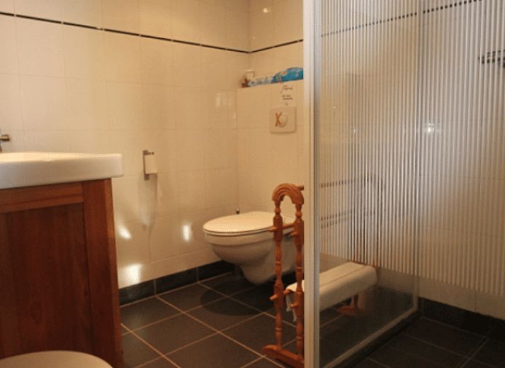 Gezellige binnenruimte van Huisje in Readtsjerk op het Friese platteland, met houten trap en knusse zithoek voor een ontspannen verblijf.