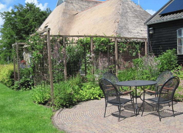 Gezellige binnenruimte van Huisje in Readtsjerk op het Friese platteland, met houten trap en knusse zithoek voor een ontspannen verblijf.