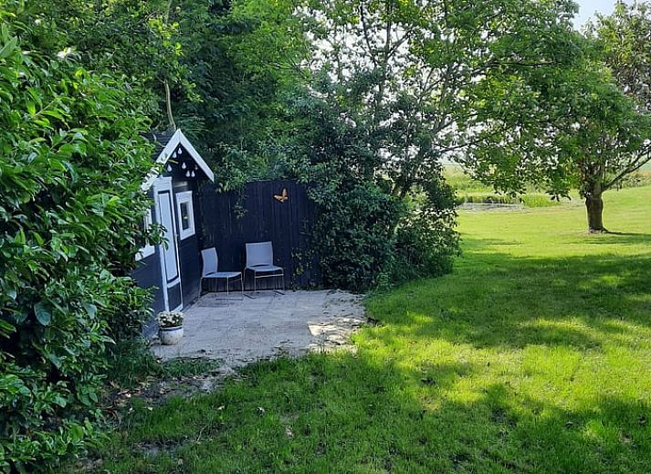 Gemuetliches Wohnzimmer des Ferienhauses in Oldelamer, Ferienhaus auf dem friesischen Land, mit grosszuegiger Sitzecke und Blick auf den Garten.