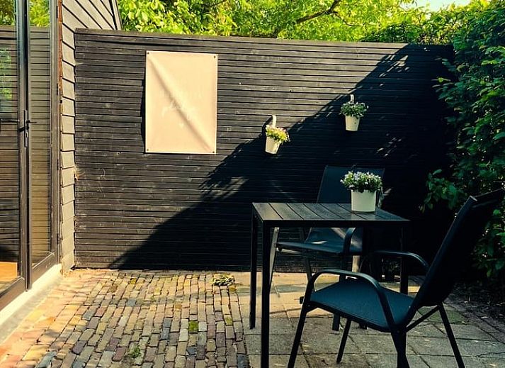 Ontspan op het terras van Vakantiehuisje in Tytsjerk, een charmante vakantiewoning in het Friese platteland, omgeven door groene natuur.