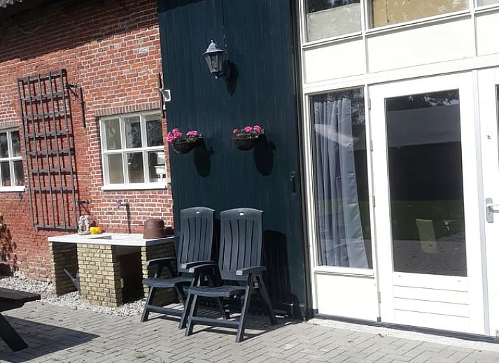 Sonnige Terrasse mit Sitzgelegenheiten im Ferienhaus in Holwerd, ideal fuer Mahlzeiten im Freien in Friesland.