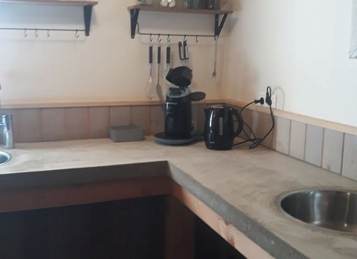 Sonnige Terrasse mit Sitzgelegenheiten im Ferienhaus in Holwerd, ideal fuer Mahlzeiten im Freien in Friesland.