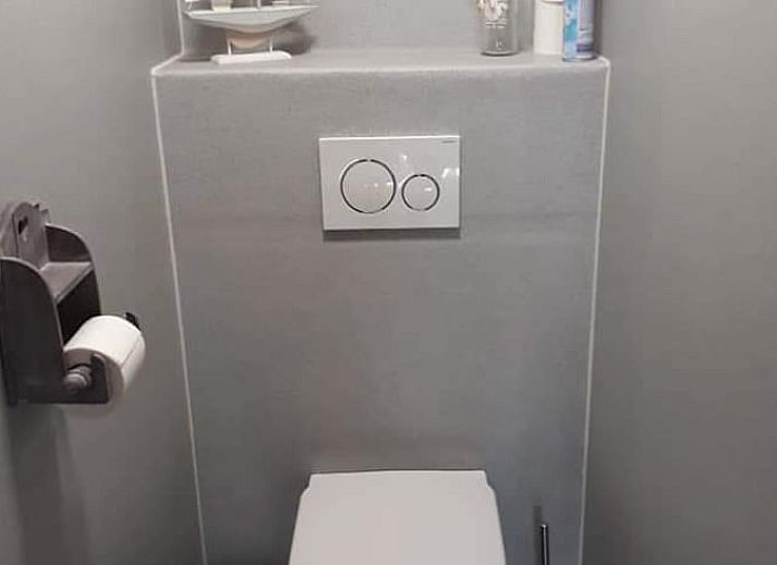 Sonnige Terrasse mit Sitzgelegenheiten im Ferienhaus in Holwerd, ideal fuer Mahlzeiten im Freien in Friesland.