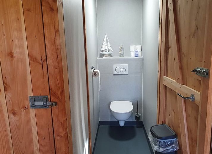 Innenraum mit Blick auf die gruene Landschaft im Ferienhaus in Holwerd, rustikales Ferienhaus in Friesland.