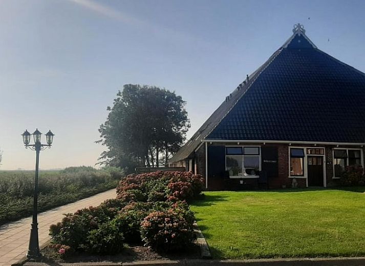 Innenraum mit Blick auf die gruene Landschaft im Ferienhaus in Holwerd, rustikales Ferienhaus in Friesland.