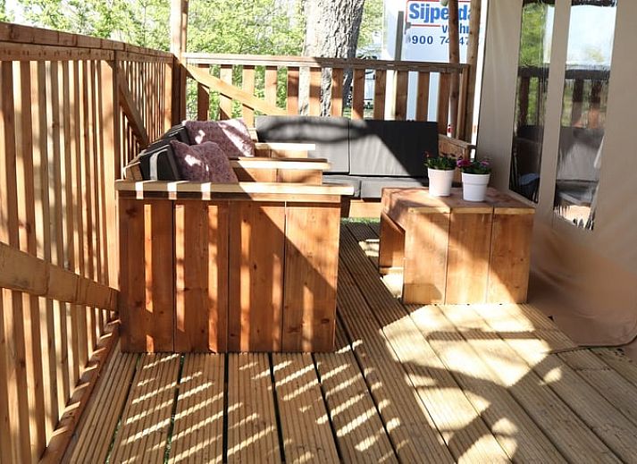 Geniet van de rust op de veranda van Huisje in Wommels, een sfeervolle safaritent op het Friese platteland in Friesland.