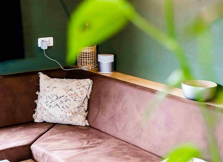 Gezellige eetruimte in Vakantiehuis in Nes, met houtkachel en gitaar aan de muur in Friesland.