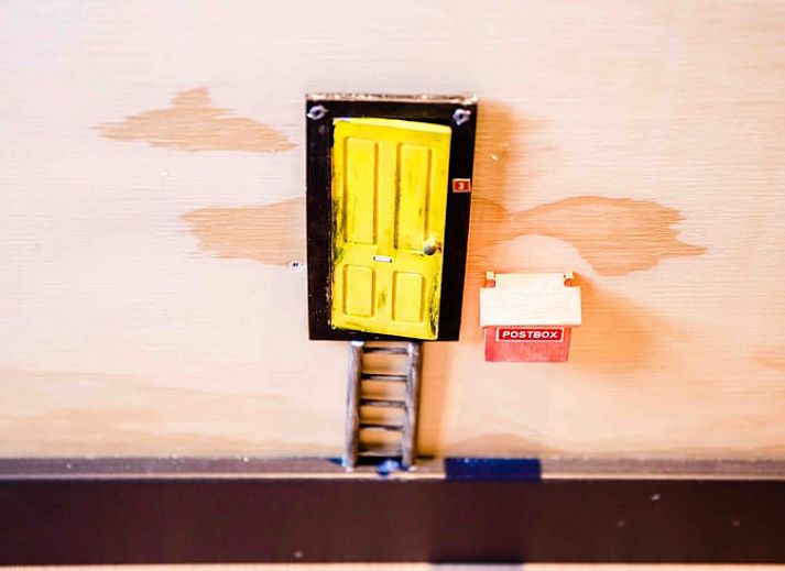 Gezellige eetruimte in Vakantiehuis in Nes, met houtkachel en gitaar aan de muur in Friesland.