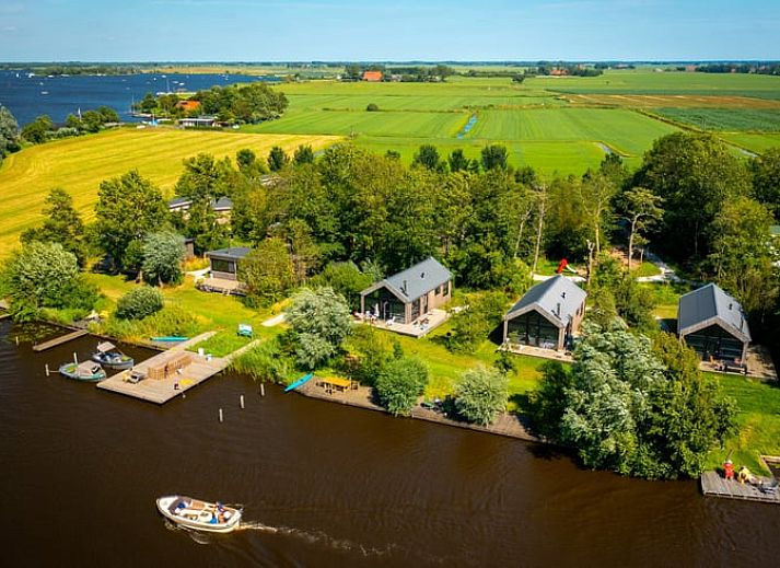 Huisje in Nes, Friesland met houten terras en groene omgeving voor een ontspannen vakantiehuis ervaring.