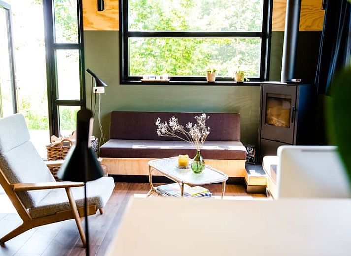 Huisje in Nes, Friesland met houten terras en groene omgeving voor een ontspannen vakantiehuis ervaring.