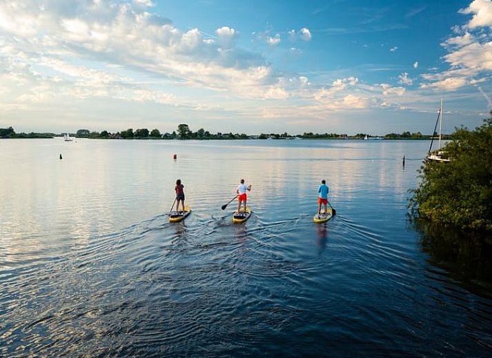Luchtfoto van Huisje in Nes, Friesland, gelegen aan het water op het prachtige Friese platteland.