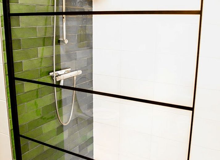 Gezellige woonkamer in Huisje in Nes, Friesland, met moderne inrichting en uitzicht op de natuur.