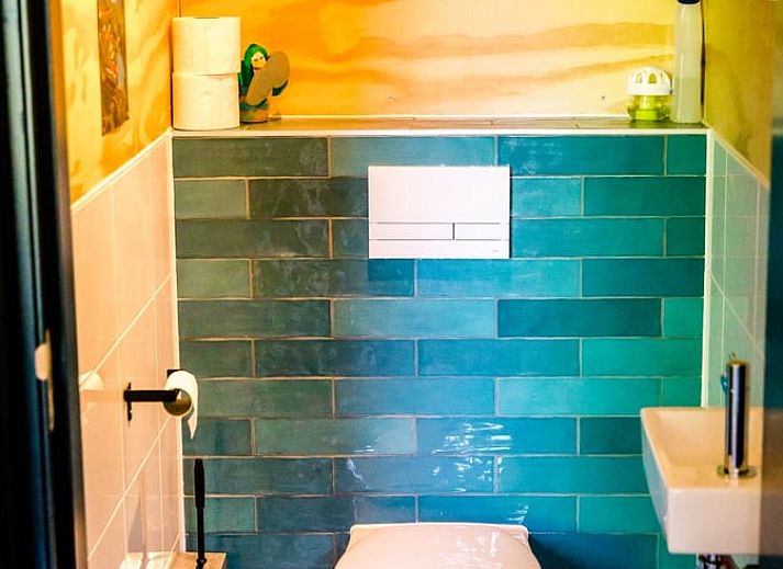 Gezellige woonkamer in Huisje in Nes, Friesland, met moderne inrichting en uitzicht op de natuur.