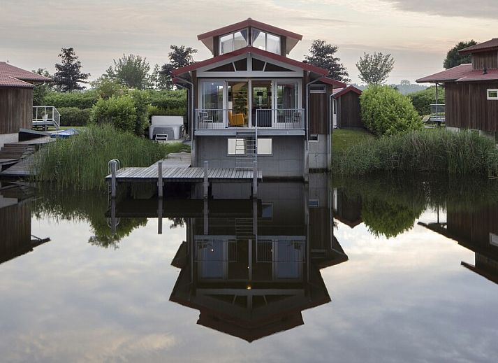 Ruime woonkamer in Goudplevier Bubbelbad 10+2, een bungalow in Noardburgum, Friesland, met uitzicht op het Friese platteland en water.