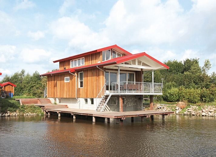 Ruime woonkamer in Goudplevier Bubbelbad 10+2, een bungalow in Noardburgum, Friesland, met uitzicht op het Friese platteland en water.