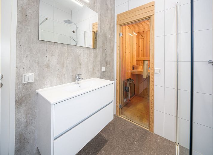 Geniessen Sie die Terrasse von Cube XL mit Sauna, einem modernen Ferienhaus fuer 4 Personen in Lathum, Gelderland, umgeben von Natur.