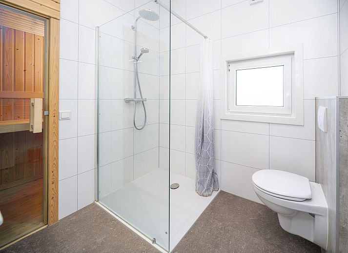 Geniessen Sie die Terrasse von Cube XL mit Sauna, einem modernen Ferienhaus fuer 4 Personen in Lathum, Gelderland, umgeben von Natur.