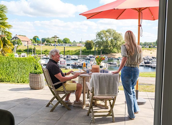 Geniessen Sie das Fruehstueck auf der Terrasse des Cube XL mit Sauna in Lathum, Gelderland, mit Blick auf den Jachthafen und die Natur.