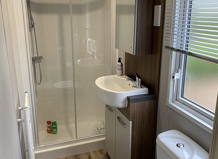 Gezellige woonkamer van Heide Lodge Comfort in Lathum, Gelderland met uitzicht op de natuur.