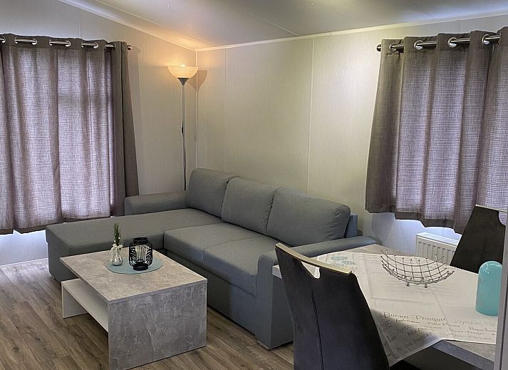 Gezellige woonkamer van Heide Lodge Comfort in Lathum, Gelderland met uitzicht op de natuur.