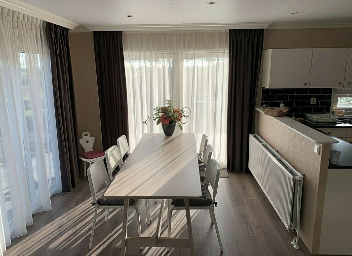 Enjoy the sun on the terrace of Zand Lodge in Lathum, Gelderland, with comfortable deck chairs and a cozy seating area for six.