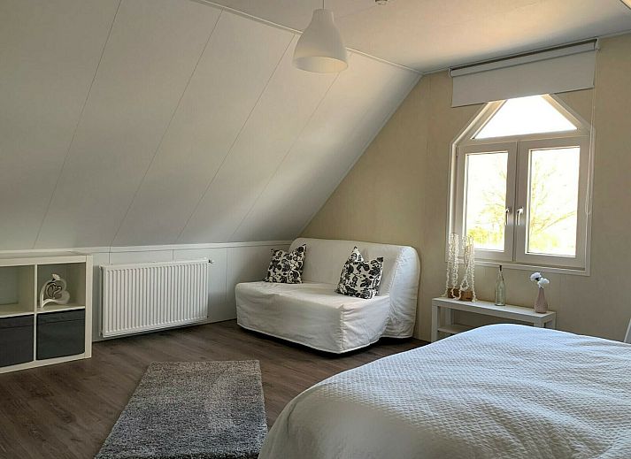 Enjoy the sun on the terrace of Zand Lodge in Lathum, Gelderland, with comfortable deck chairs and a cozy seating area for six.